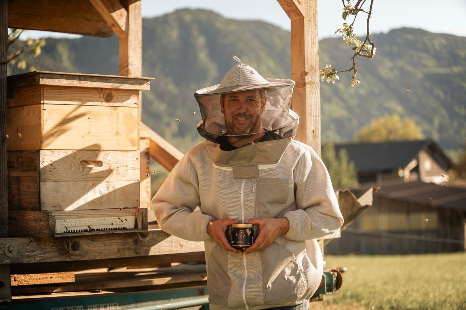 Imker mit Bienenstock im Morgenlicht